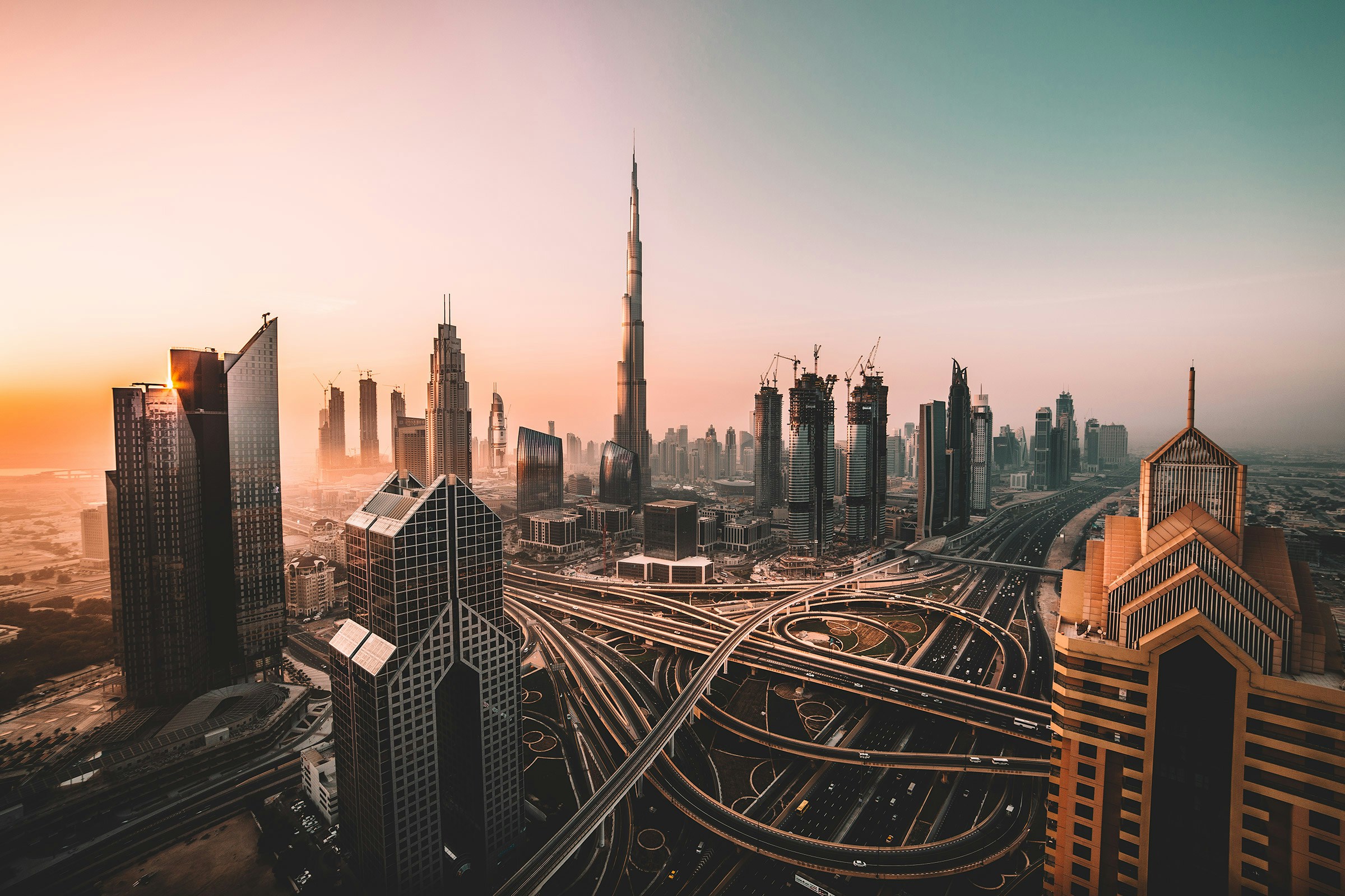 Aerial view of Downtown Dubai at sunrise showing city skyline and infrastructure