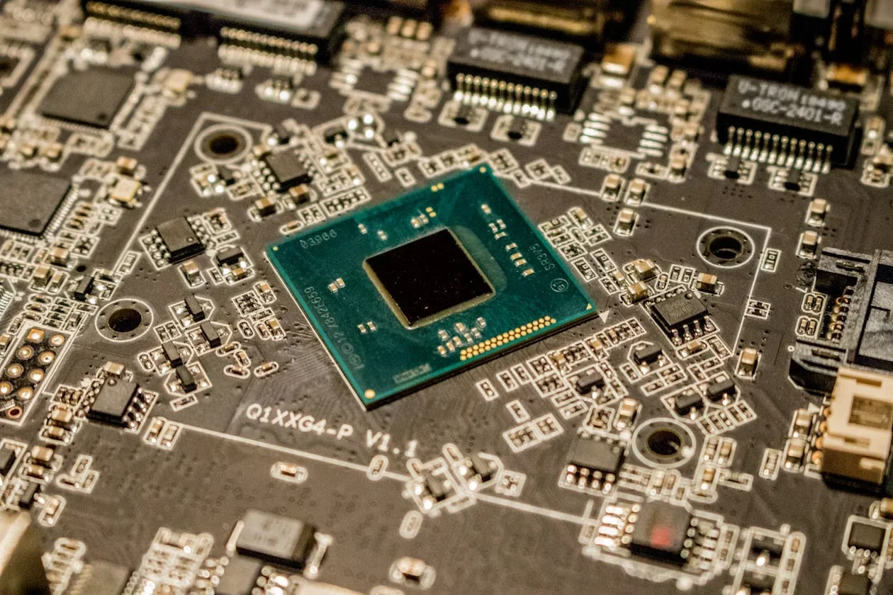 Close-up of a green processor chip mounted on a dark circuit board with small components around it
