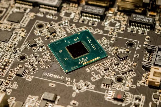 Close-up of a green processor chip mounted on a dark circuit board with small components around it