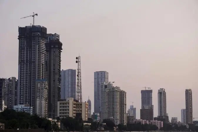 Skyline of high-rise towers, some under construction with cranes, in a hazy pink dusk sky