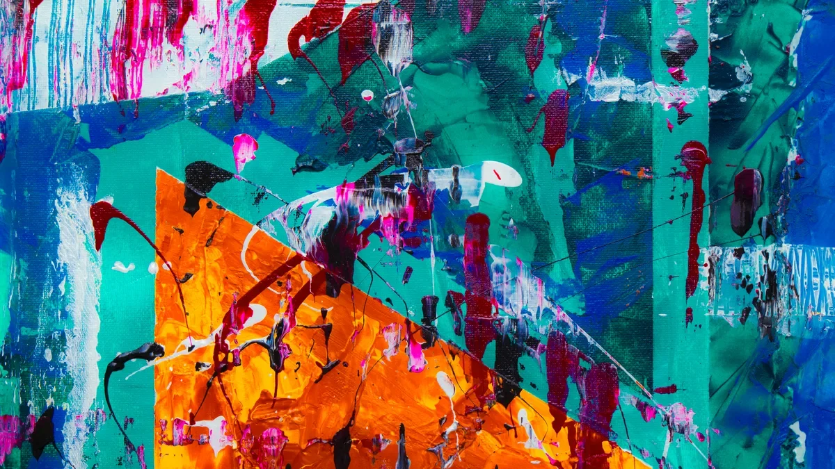 Abstract painting with splashes of orange, teal, blue, red and pink paint