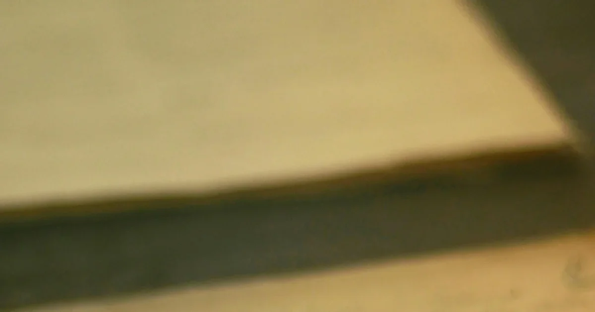 Blurred close-up of a flat beige surface edge with soft shadows, an abstract image with no visible subject