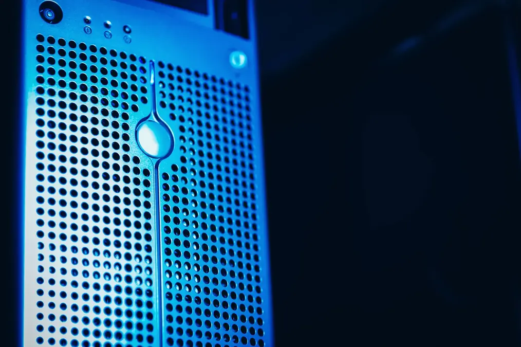 Close-up of a server front panel with a perforated metal grille lit in blue light