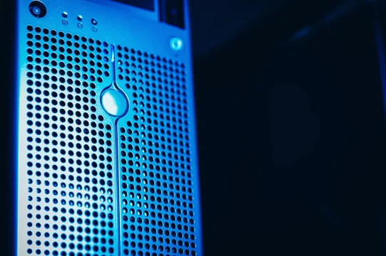 Close-up of a server front panel with a perforated metal grille lit in blue light