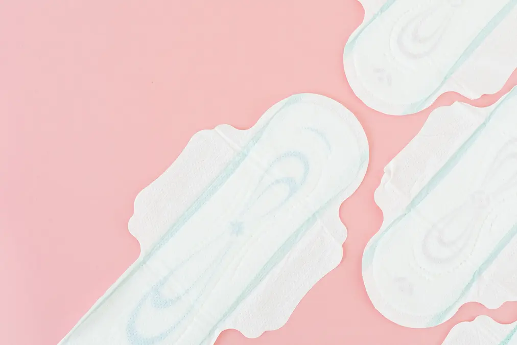 Sanitary pads laid out on a soft pink background