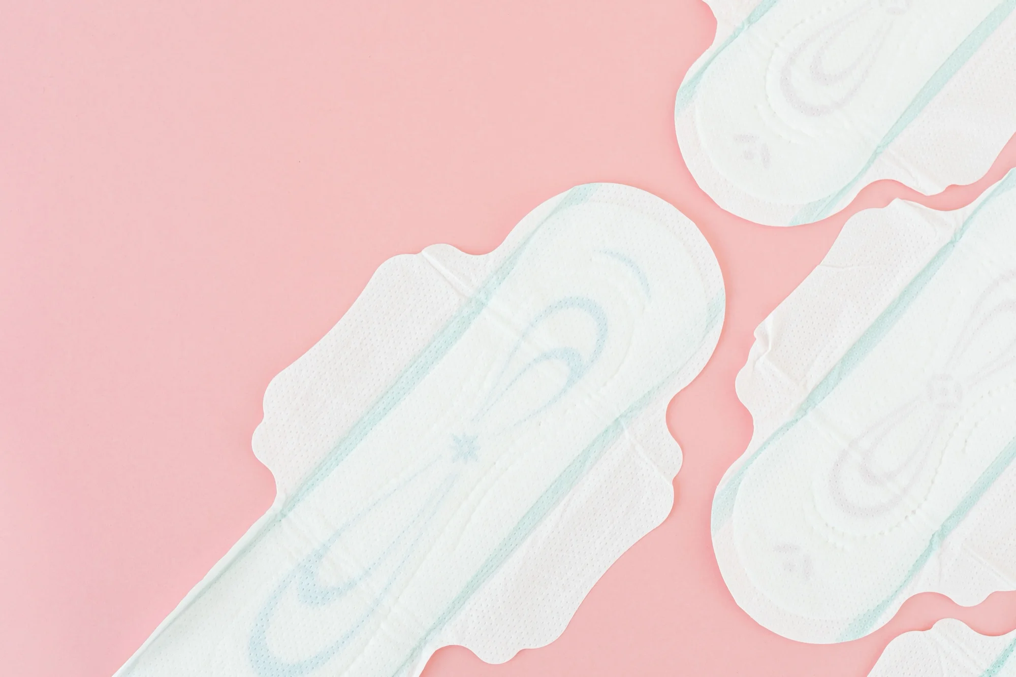 Sanitary pads laid out on a soft pink background