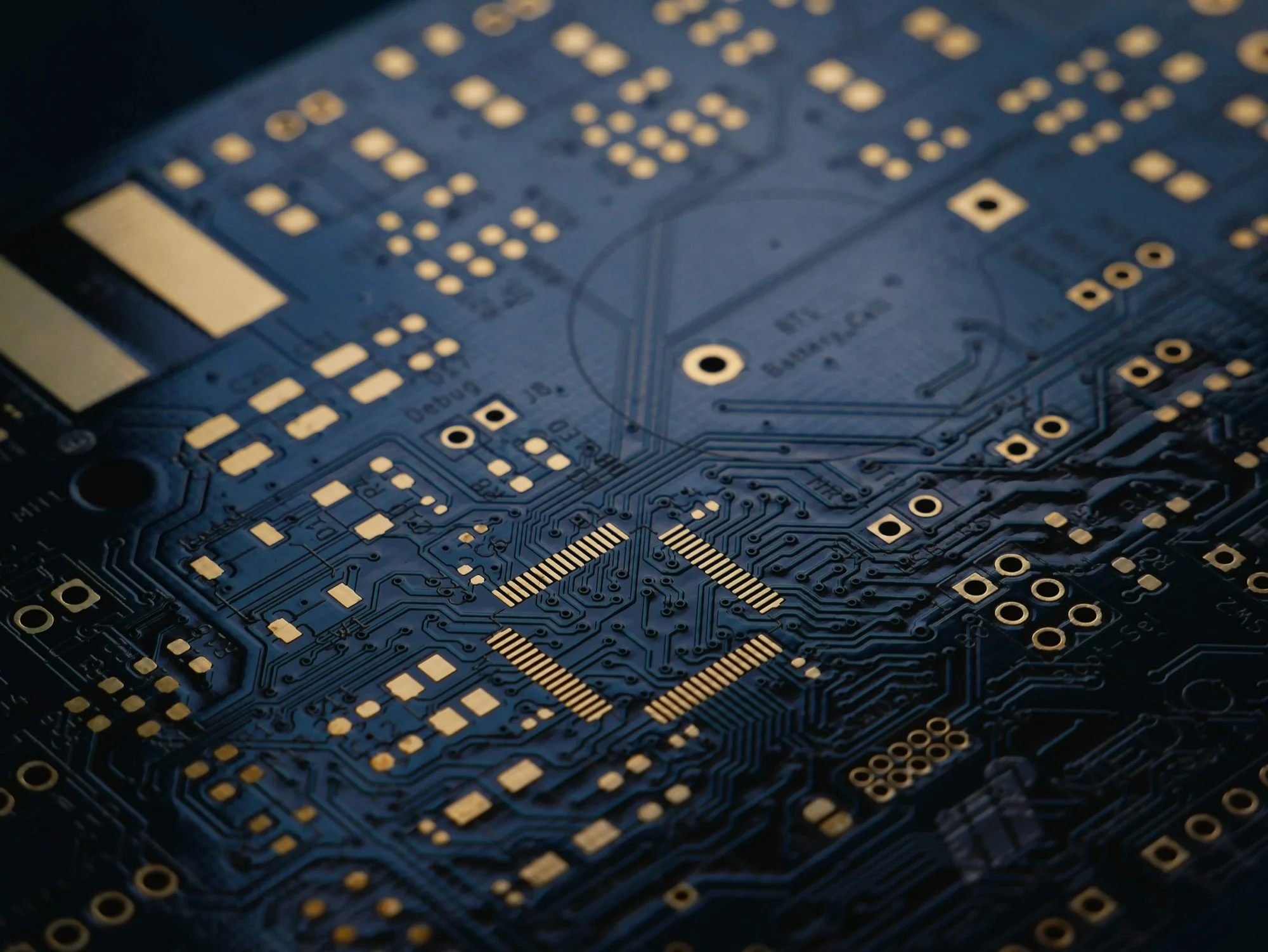 Close view of a dark blue circuit board with gold contact pads