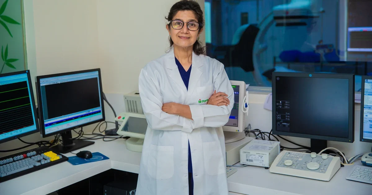 A woman doctor with arms crossed stands in a medical laboratory in Delhi, India