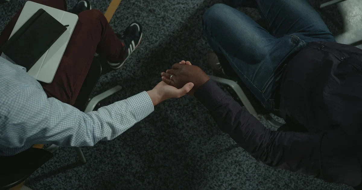 Two people shake hands during a counselling session, a first step towards treatment for addiction