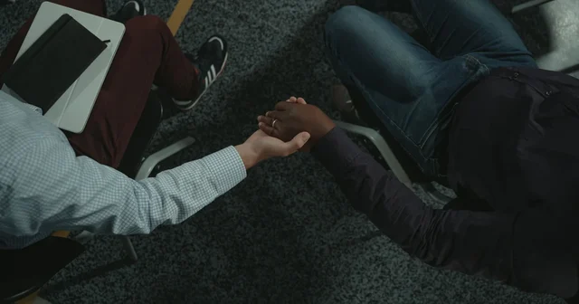Two people shake hands during a counselling session, a first step towards treatment for addiction