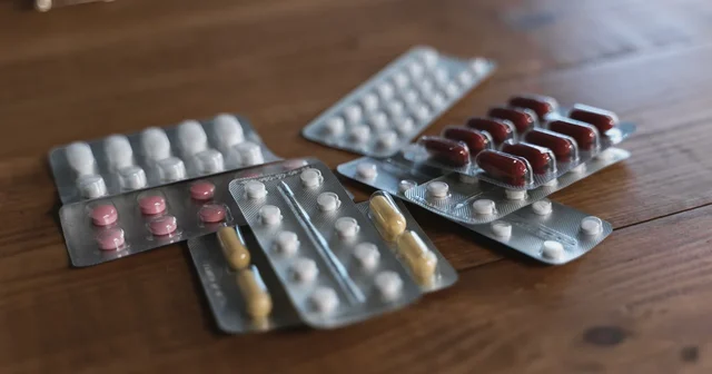 Tablets in blister packs on a wooden surface, illustrating antibiotic resistance in India and the need to take antibiotics only on prescription