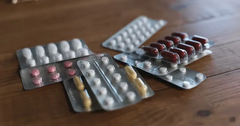 Tablets in blister packs on a wooden surface, illustrating antibiotic resistance in India and the need to take antibiotics only on prescription