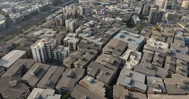 Aerial view of densely packed buildings and roads across Mumbai, showing the housing shortage in India's cities
